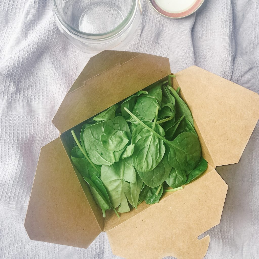 spinach in a cardboard box with mason jar