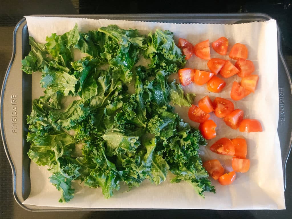 kale and tomatoes on a sheet pan