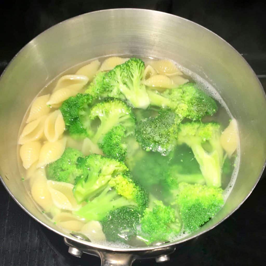 pasta and frozen broccoli in boiling water